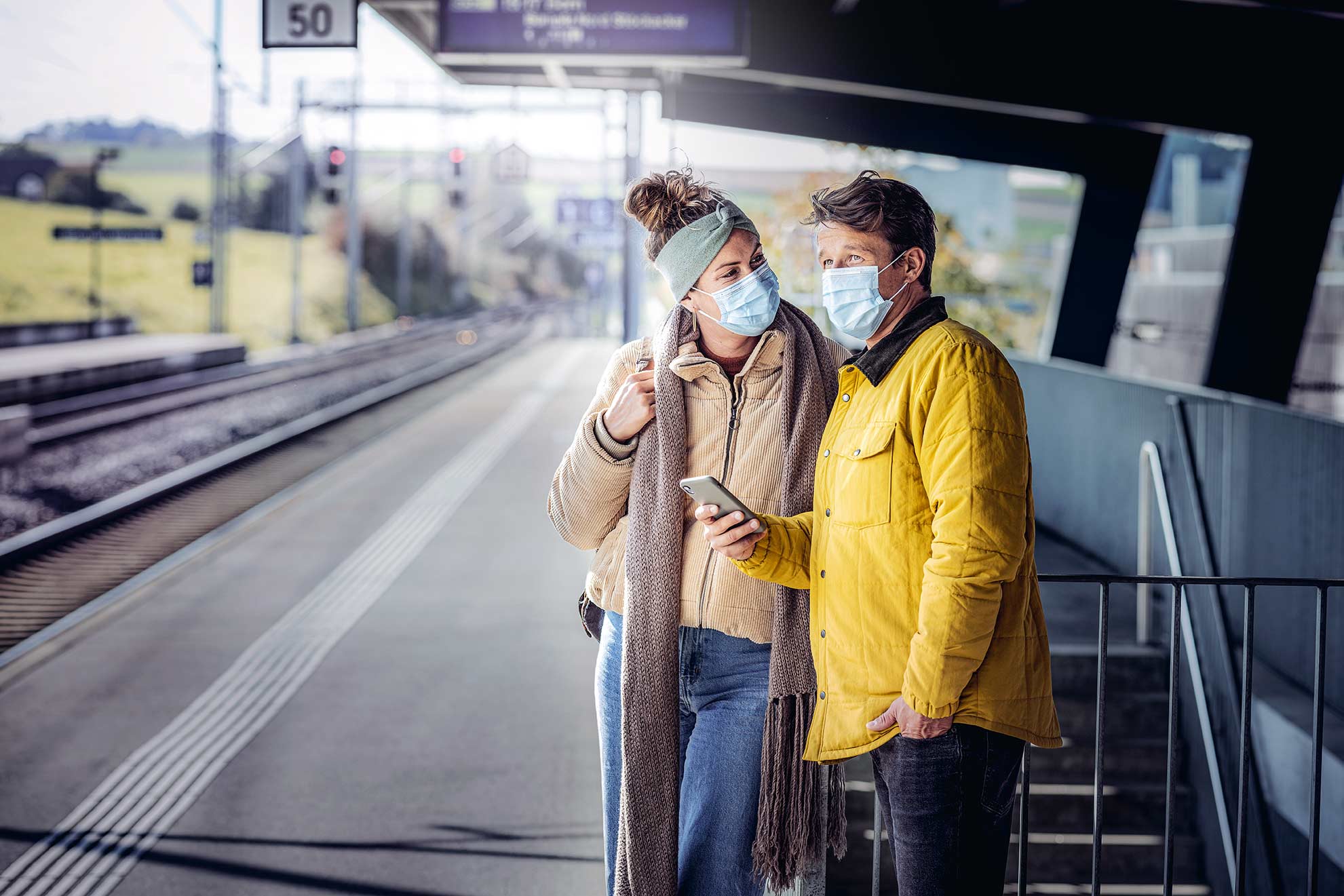 Paar mit Maske am Bahnhof
