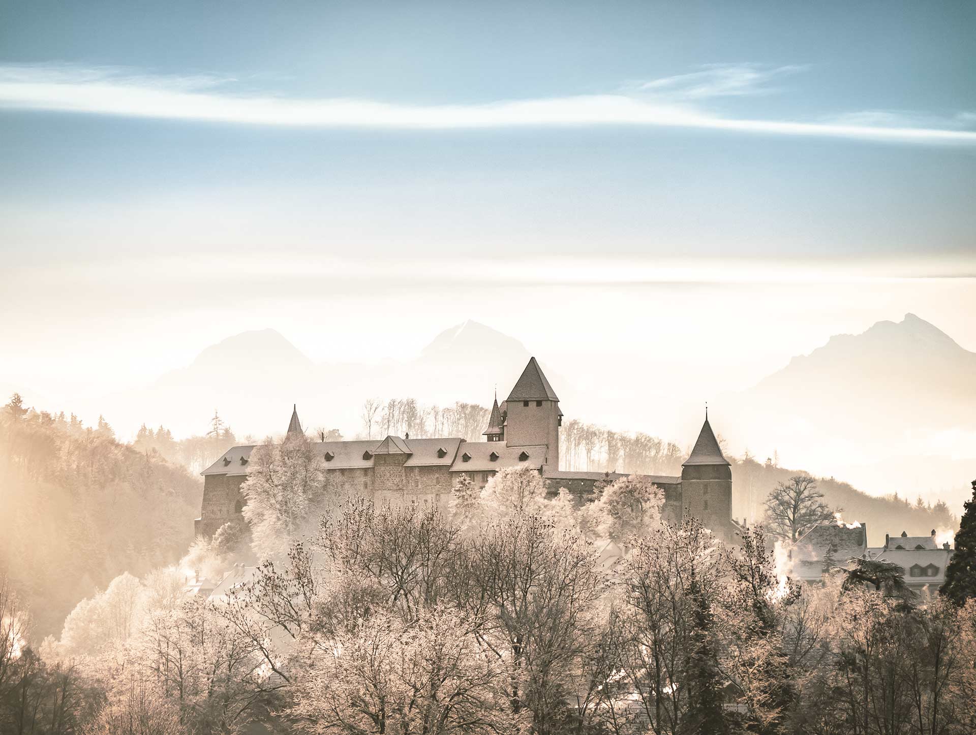 Schloss Burgdorf im Winter von schneebedeckten Bäumen umgeben