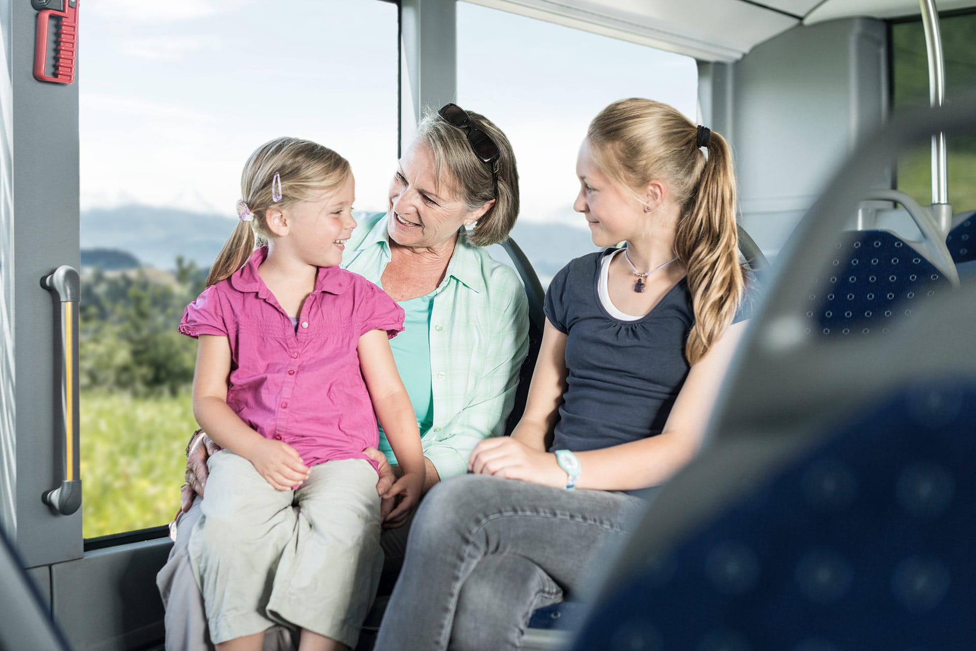 Mutter mit Töchtern geniesst die Fahrt im Wanderbus zur Lüderenalp.