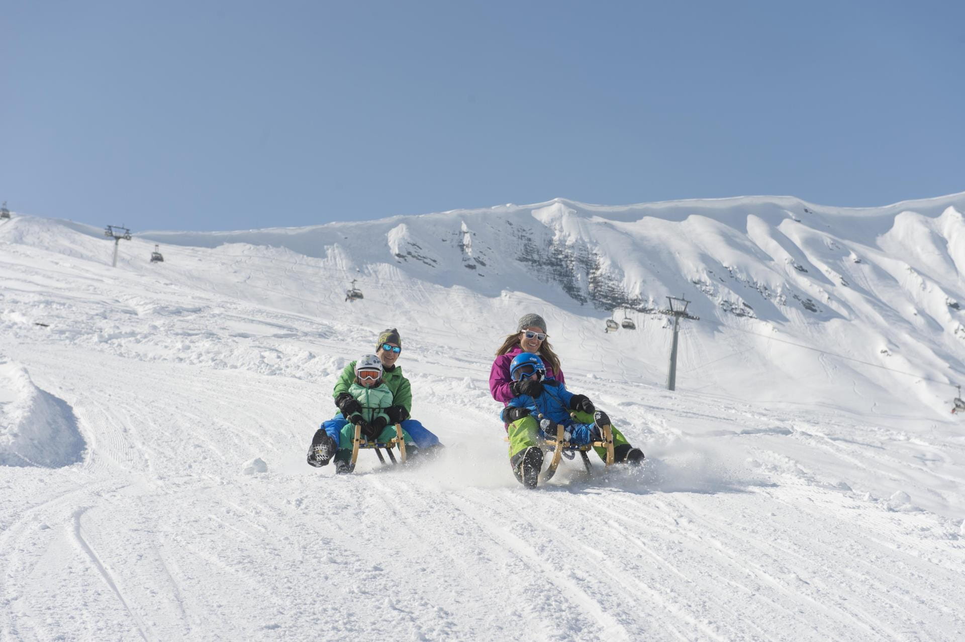 Familie beim Schlitteln auf der Tschentenalp