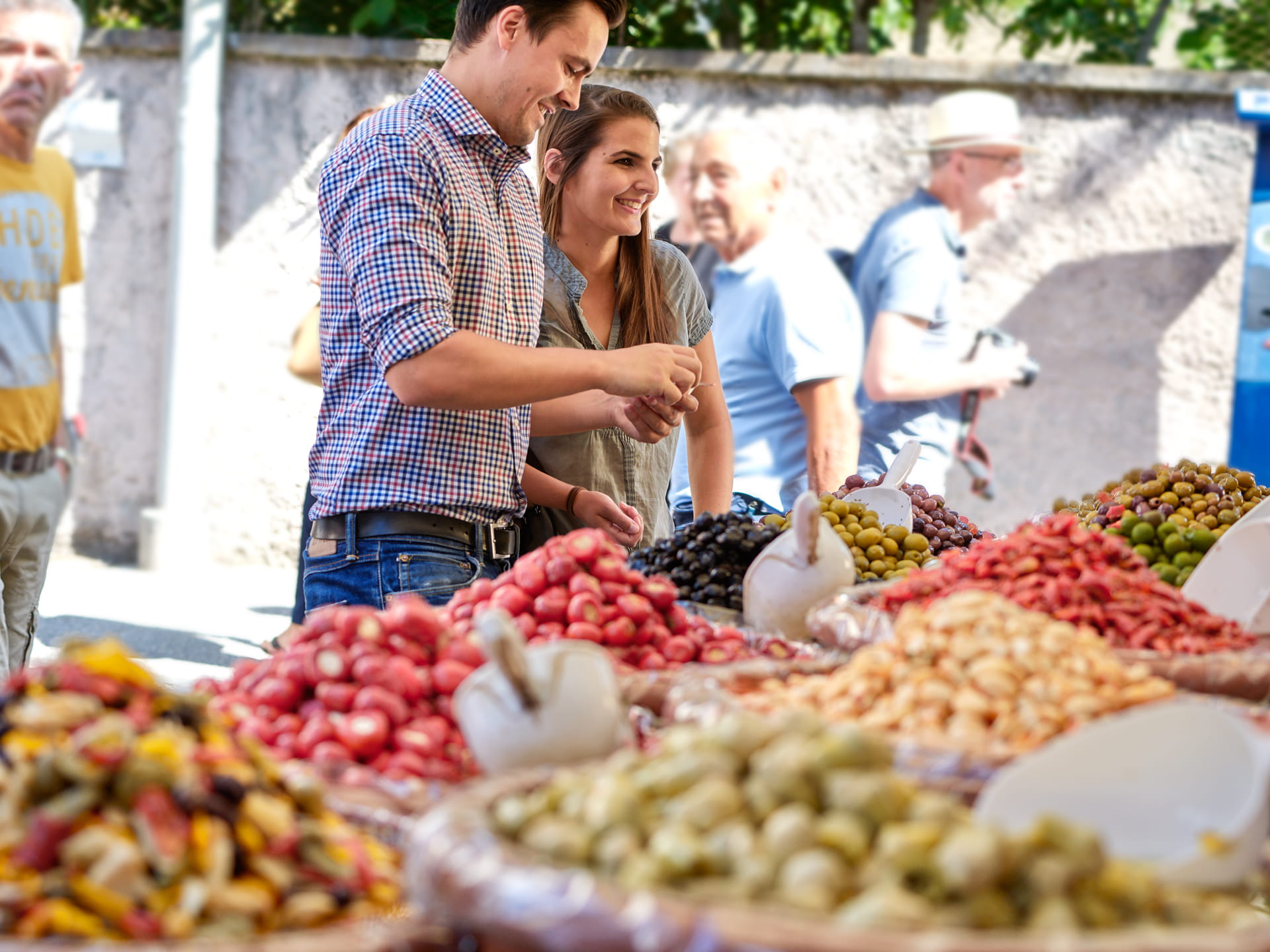 Ein junges Paar verhandelt mit dem Verkäufer über den Preis der Antipasti.
