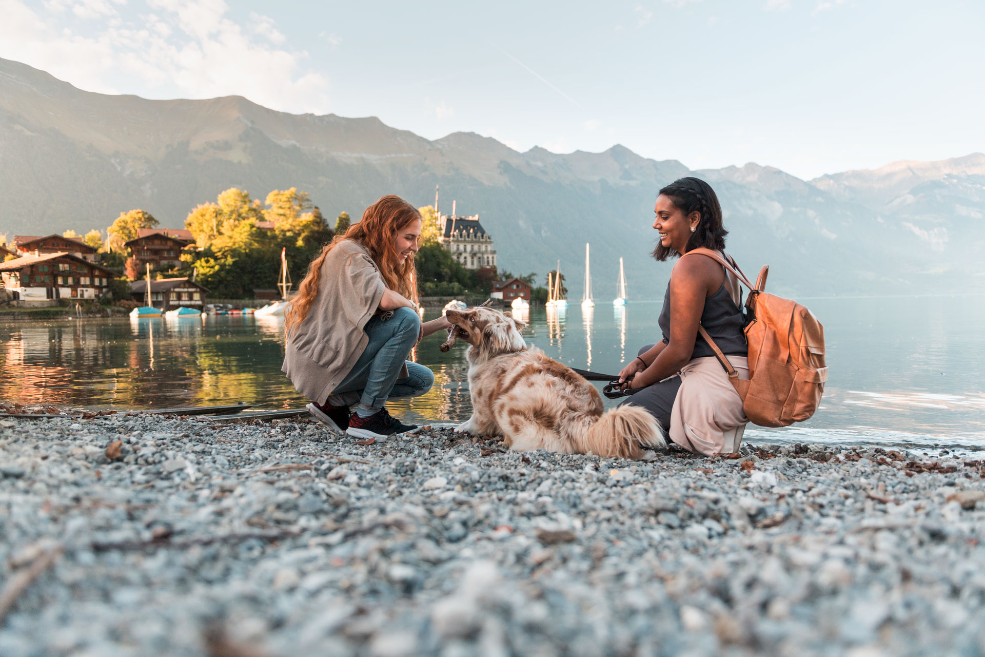 Zwei Frauen mit Hund entspannen am Ufer des Brienzersees