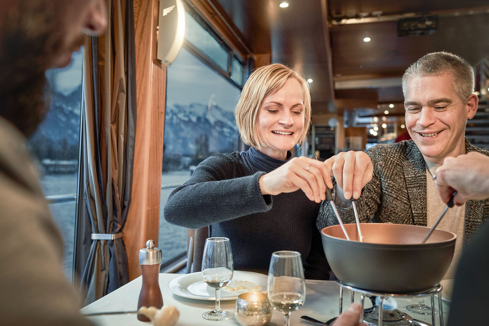 People eating Swiss cheese fondue on a boat