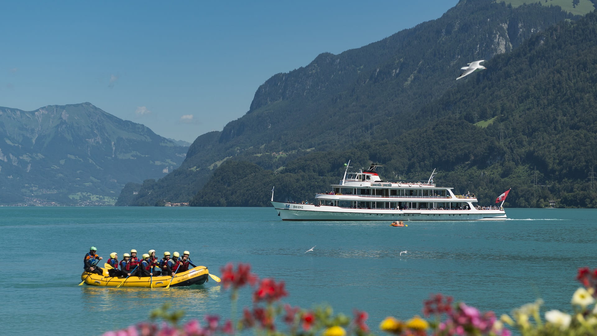 MS Brienz auf türkisfarbenem Brienzersee, gelbes Schlauchboot mit Personen links im Bild